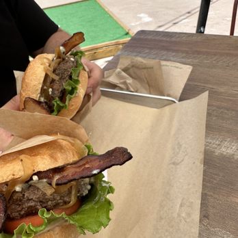 CP Burger - two hands holding two sandwiches - Burgers Near Me - Aspen, Colorado