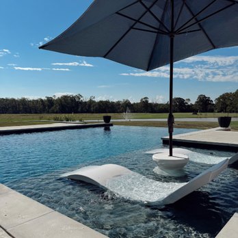 Pinnacle Exterior Construction - Infinity edge pool with tanning ledge and pool loungers. - Fences & Gates Near Me - Baton Rouge, Louisiana