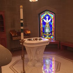 St. Therese Catholic Church - Baptismal font and stain glass window near the center of the church