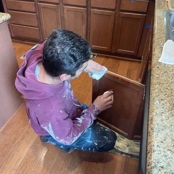 Noor Construction - One of the workmen is touching up the stain on our kitchen cabinets. - General Contractors Near Me Noor Construction - One of the workmen is touching up the stain on our kitchen cabinets. - General Contractors Near Me