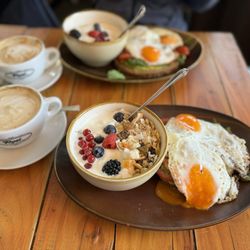 Rosi - Gesund breakfast - avocado toast, fried eggs, granola with yogurt and berries and big latte.