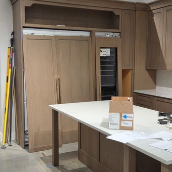 Mid South Installations - Popular White Oak riff cabinets including three 1.25" doors covering wine cooler on right and double doors on refrigerator. - Cabinetry Near Me - Iron Station, North Carolina Mid South Installations - Popular White Oak riff cabinets including three 1.25" doors covering wine cooler on right and double doors on refrigerator. - Cabinetry Near Me - Iron Station, North Carolina