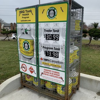 Petro-Canada - Petro-Canada & Car Wash - propane - A metal cage filled with propane cylinders is positioned outdoors, showing prices for Trader Tank and Program Tank, along with safety warnings and contact details. - Gas Stations Near Me - Concord, Ontario