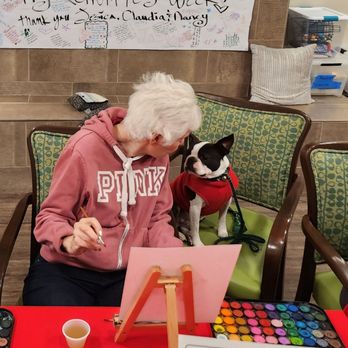 Silverado Rolling Hills Memory Care Community - Sharing painting techniques with her visiting grand-dog. - Assisted Living Facilities Near Me - Torrance, California