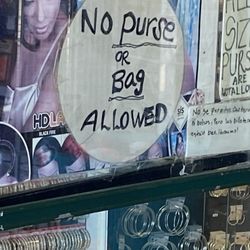 Black Diamond Beauty Supply - A handwritten sign stating no purse or bags or allowed in the store while you shopping to make a purchase.