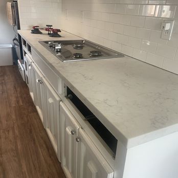 JC Tile & Countertops - White quartz countertop with stainless steel appliance. - Tiling Near Me JC Tile & Countertops - White quartz countertop with stainless steel appliance. - Tiling Near Me