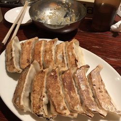 Photo of 原宿餃子樓 - Shibuya, 13, JP. Seat at the bar, gyoza, and missing miso cucumbers
