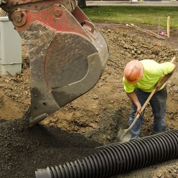 28 Blue Construction - a construction worker digging a trench - Excavation Services Near Me