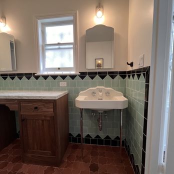 Dunros Construction - a bathroom with a sink and mirror - General Contractors Near Me