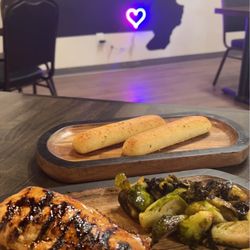 1808 Public House - One of the signature dishes. (Appears to be grilled chicken, smashed brussel sprouts, & breadsticks)