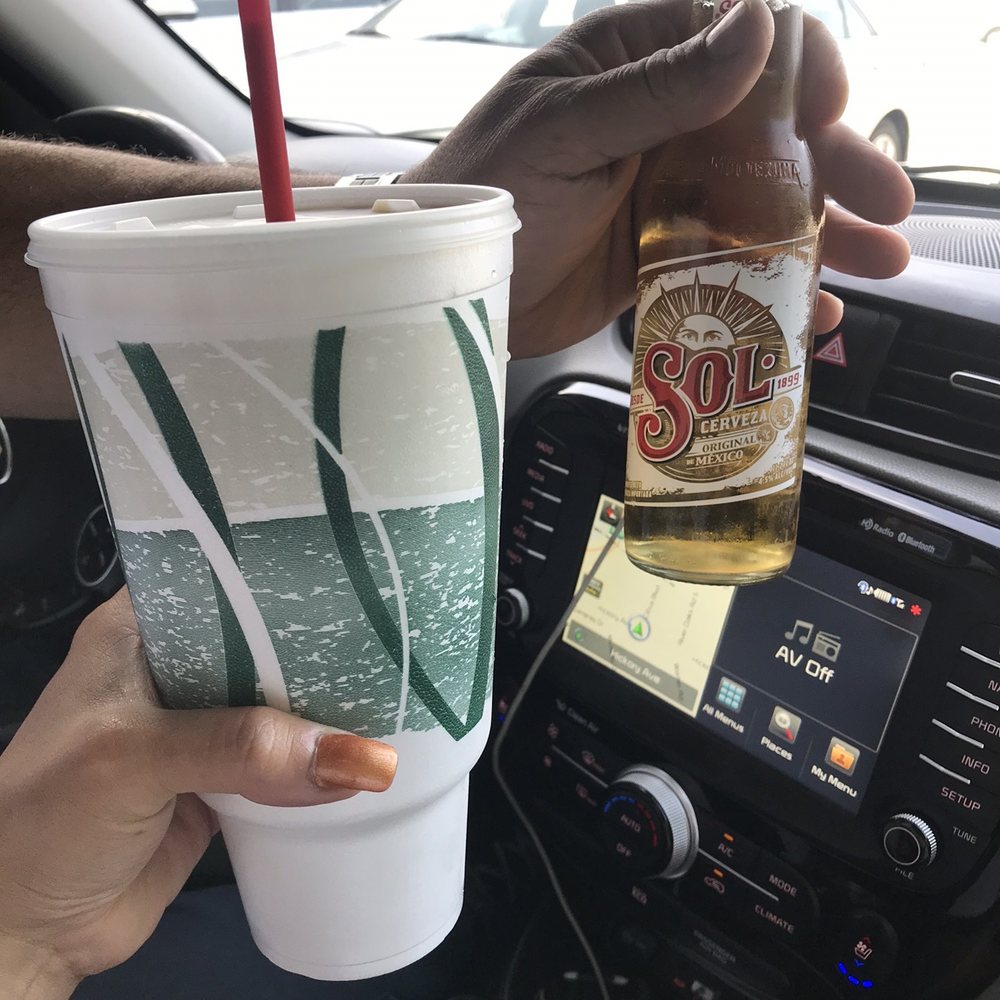 Daquiri Stop - a person holding a drink in a car - Sports Bars Near Me - Harahan, Louisiana Daquiri Stop - a person holding a drink in a car - Sports Bars Near Me - Harahan, Louisiana