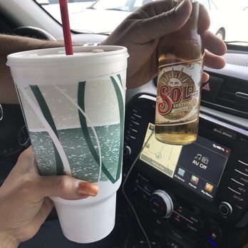 Daquiri Stop - a person holding a drink in a car - Sports Bars Near Me - Harahan, Louisiana