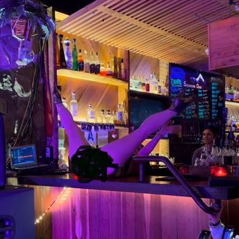 Sycamore Den - Woman bare behind on the bar top. - Cocktail Bars Near Me - San Diego, California