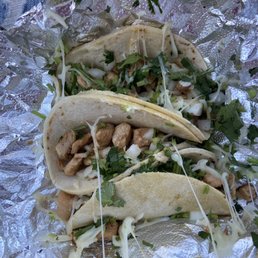 Chicken tacos with homemade corn tortillas topped with onion, cilantro, and a squeeze of lime.
