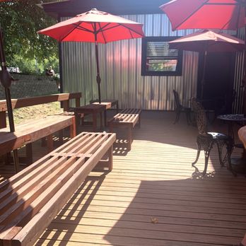 Vista Ridge Winery - a wooden deck with tables and umbrellas - Wine Tasting Room Near Me - Alden, Michigan Vista Ridge Winery - a wooden deck with tables and umbrellas - Wine Tasting Room Near Me - Alden, Michigan