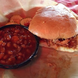 BBQ pulled chicken sandwich and baked beans. BBQ pulled chicken sandwich and baked beans.