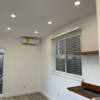 Conex Modular - a kitchen with white walls and wood floors - General Contractors Near Me