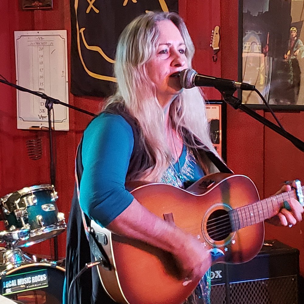 Bartini Bar - a woman playing a guitar and singing into a microphone - Music Venues Near Me - Babylon, New York Bartini Bar - a woman playing a guitar and singing into a microphone - Music Venues Near Me - Babylon, New York