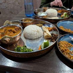 Mitho Nepali - Fish thali in foreground; vegetarian thali behind.