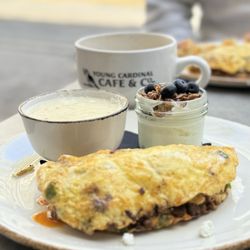 Young Cardinal Cafe - Chorizo, pepper, onion, goat cheese omelette. Sm yogurt w/homemade honey granola + berries, grits. Salted Caramel Oat Milk Latte +