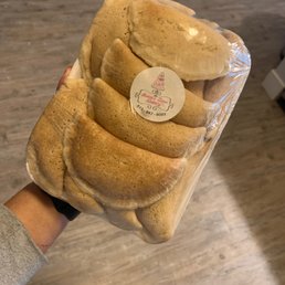 a hand holding a loaf of bread a hand holding a loaf of bread