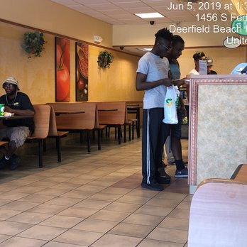 Subway - a man standing at a table in a restaurant - Fast Food Near Me - Deerfield Beach, Florida
