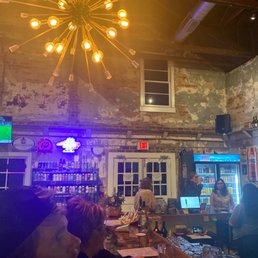 people sitting at a bar with a chandelier in the background people sitting at a bar with a chandelier in the background