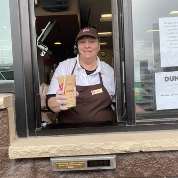 Dunkin' -  a man holding a bag of dunkin donuts - Coffee & Tea Near Me - Coralville, Iowa