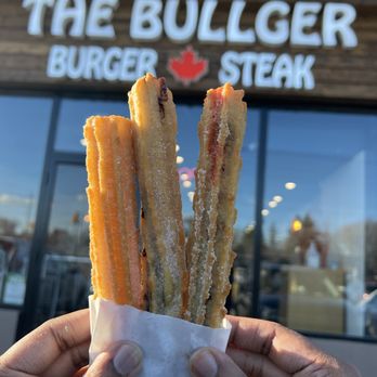 The Bullger - a hand holding a sandwich outside of the burger steak - Burgers Near Me - Toronto, Ontario The Bullger - a hand holding a sandwich outside of the burger steak - Burgers Near Me - Toronto, Ontario