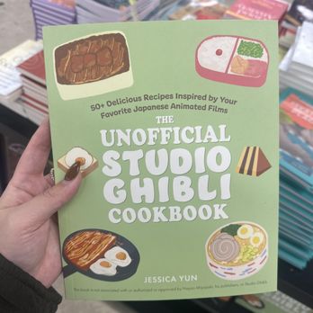 Five Below - A person holds a green cookbook titled 'The Unofficial Studio Ghibli Cookbook' with illustrations of Japanese dishes on the cover, displayed at a bookstore. - Accessories Near Me - Freeport, New York