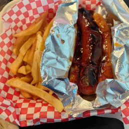 Hot link in a bun with French fries Hot link in a bun with French fries