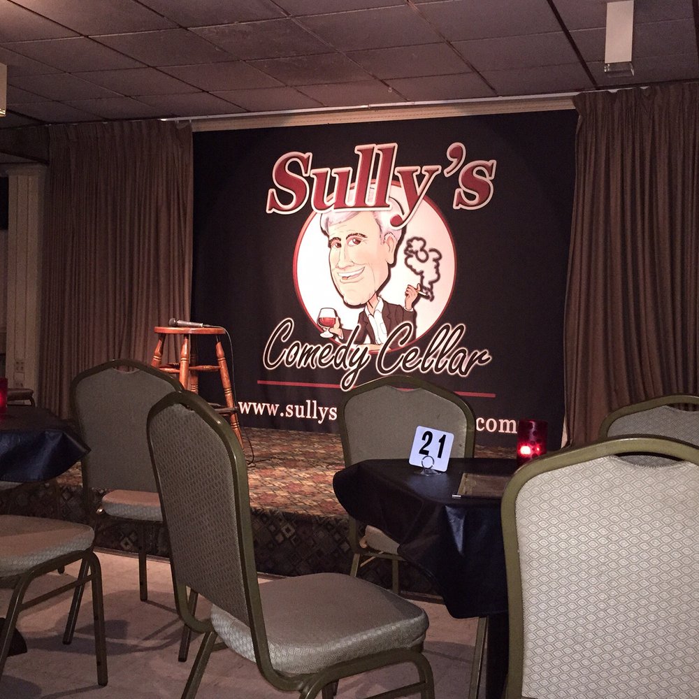 a stage with chairs and a sign