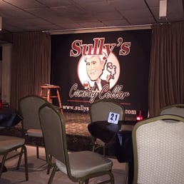a stage with chairs and a sign