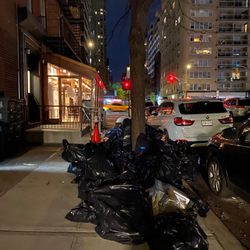 2nd Ave Deli - Trash from 2nd Avenue Deli on SE corner of 75th and 1st. Rats feed on trash bags opposite open restaurant door.