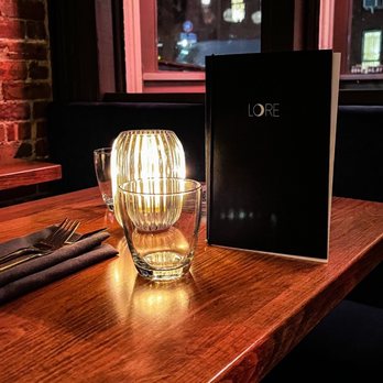 Lore - a table with a lit candle and a menu on it - Indian Near Me - Brooklyn, New York Lore - a table with a lit candle and a menu on it - Indian Near Me - Brooklyn, New York