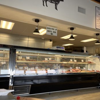 The Village Butcher - a woman standing in front of the counter - Delis Near Me - Modesto, California The Village Butcher - a woman standing in front of the counter - Delis Near Me - Modesto, California