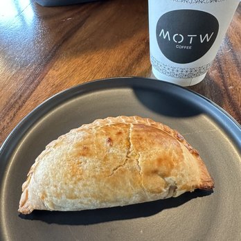 MOTW Coffee - Cup of hot coffee (vanilla coconut latte) in a to-go cup, and a beef empanada. - Coffee & Tea Near Me - Lombard, Illinois MOTW Coffee - Cup of hot coffee (vanilla coconut latte) in a to-go cup, and a beef empanada. - Coffee & Tea Near Me - Lombard, Illinois