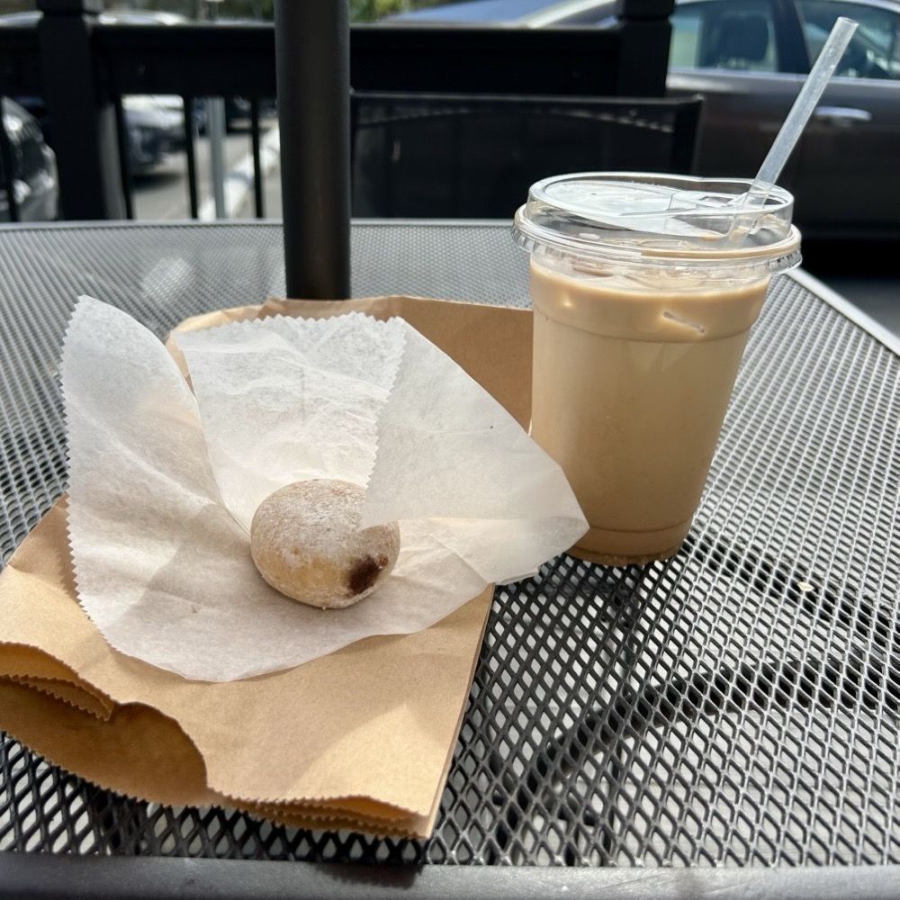 Old Mill Cafe - A fresh brioche-like powdered-sugar-coated jelly donut and creamy fresh hot coffee in and enclosed courtyard - Coffee & Tea Near Me - Ellicott City, Maryland