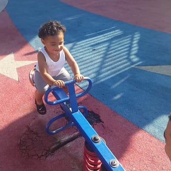 Freedom Park - Playing on seesaw with daddy...watch out for the flooring though. Its worn and tore up, as you can see by his feet. Water damage I guess. - Parks Near Me - Modesto, California