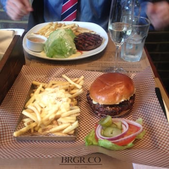 BRGR.CO - 8oz burger with blue cheese on top of the patty.  Fries with truffled oil and cheese. My friend had 8oz burger steak. - Burgers Near Me - London, XGL