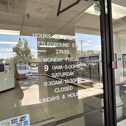 United State Postal Service - The front door with hours of operation of the USPS - Battleground Office in Greensboro, NC.