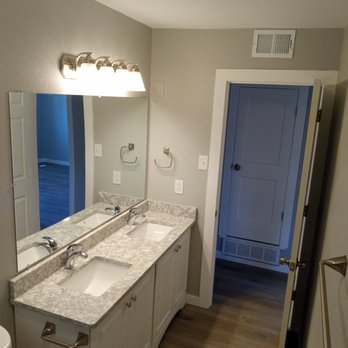 Behm Contracting - a bathroom with two sinks and a blue door - General Contractors Near Me
