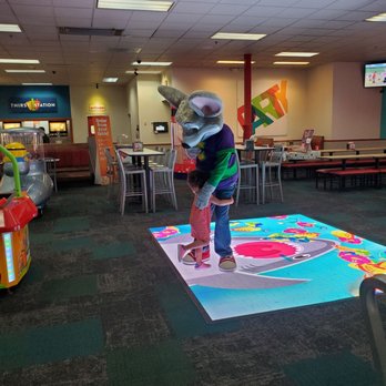 Chuck E. Cheese - a child standing on a play mat in a playroom - Pizza Near Me - Oklahoma City, Oklahoma Chuck E. Cheese - a child standing on a play mat in a playroom - Pizza Near Me - Oklahoma City, Oklahoma