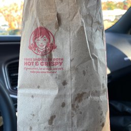 a person holding a paper bag in their hand a person holding a paper bag in their hand