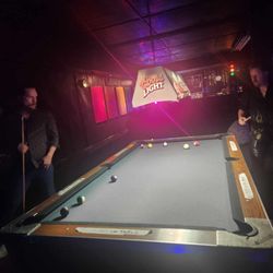Zig's - My partner and our buddy playing pool at the table in front of the bar.