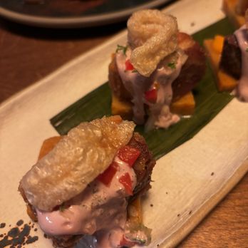 Suyo Modern Peruvian - PORK BELLY CHICHARRON roasted yam puree, salsa criolla, polenta tamal, olive emulsion - Peruvian Near Me - Vancouver, British Columbia