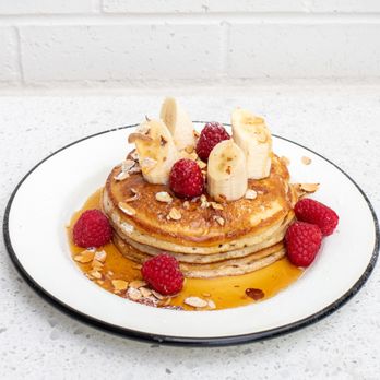 Cubby's - Whole Wheat and All Purpose Flour Pancakes with fresh Bananas, Raspberries, Toasted Almonds, Pure Maple Syrup, Topped with Powdered Sugar - New American Near Me - South Jordan, Utah