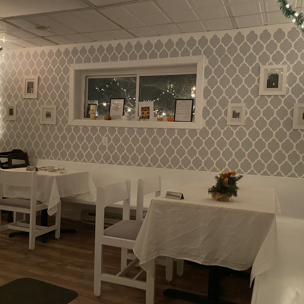 a dining room with white tables and white chairs a dining room with white tables and white chairs