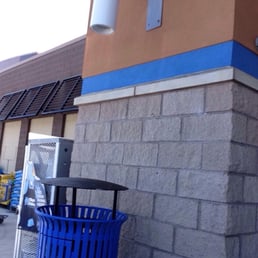 a blue trash can in front of a store a blue trash can in front of a store