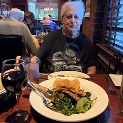 Friend enjoying grilled sausage, broccoli rabe & sliced potatoes with hot peppers.